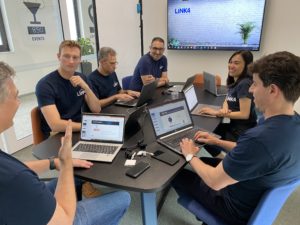 Link4 team sitting in a meeting room with laptops