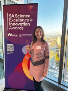 Sandra Vallance, CEO of SABRENet, standing infront of the SA Science Awards banner at the awards certificate ceremony