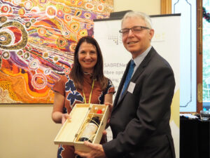 S.Vallance presenting a bottle pf wine to P.Sherlock